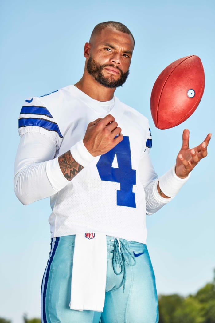 Dak Prescott tosses a football to himself in a posed photograph
